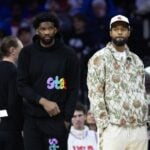 Injured Philadelphia 76ers Paul George (R) and Joel Embiid (L) look on during the first quarter